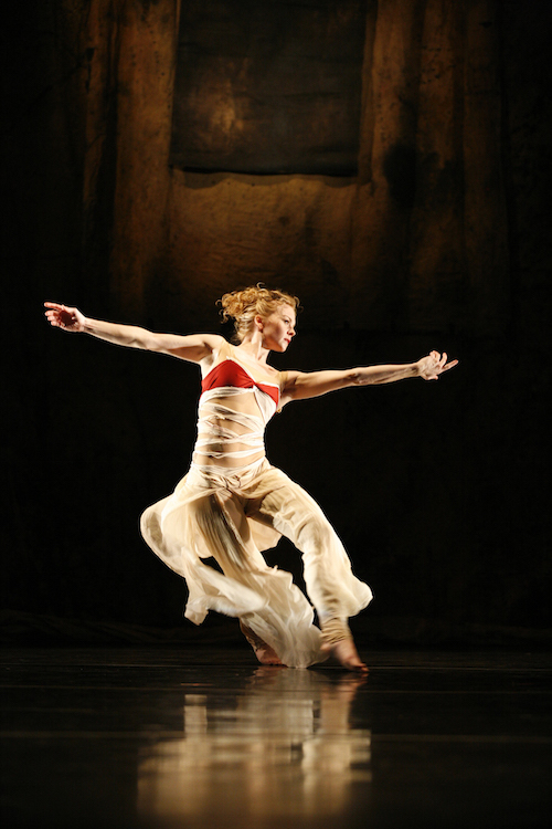 A woman in an inventive costume that billows as the dancer moves while the top exposes some of her toned torso